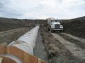 After pipe support blocks were set and the drop inlet riser was connected, high-slump concrete bedding was poured in the trench.