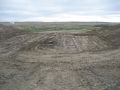 This photo shows the excavated embankment with the bottom compacted. The pipe trench will be excavated from this compacted surface.