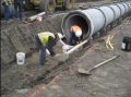 The trench has been excavated. The pipe is being set on Pipe Support Blocks.