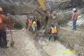 Setting pipe support blocks. Note water in trench.