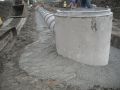 Concrete bedding around drop inlet riser.