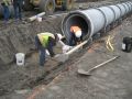 The trench has been excavated. The pipe is being set on Pipe Support Blocks.