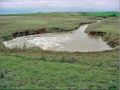 Unlined plunge basin (view is looking downstream). This basin has been allowed to scour over time.