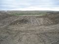 This photo shows the excavated embankment with the bottom compacted. The pipe trench will be excavated from this compacted surface.